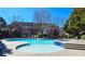 Outdoor pool and jacuzzi area with lounge chairs, surrounded by well-maintained landscaping and residential buildings at 3699 Ashford Creek Ne Hl, Atlanta, GA 30319