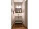 Powder room with wood floors, wainscoting, a framed mirror and a vanity with storage at 3699 Ashford Creek Ne Hl, Atlanta, GA 30319