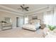 Large, bright main bedroom boasts neutral decor, tray ceiling, and natural light from many windows at 3910 Cameron Ct, Cumming, GA 30040