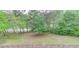 Expansive backyard with a well-maintained lawn and a view of the woods and lake beyond at 2400 Weber Heights Way, Buford, GA 30519