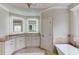 Bright bathroom with illuminated mirrors, granite countertops, and standalone soaking tub at 2400 Weber Heights Way, Buford, GA 30519