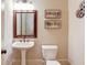 Powder bath featuring a pedestal sink, toilet, and decorative movie-themed decor at 2400 Weber Heights Way, Buford, GA 30519