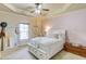 Cozy bedroom with tray ceiling, ceiling fan, and window providing natural light at 2400 Weber Heights Way, Buford, GA 30519