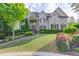 Charming two-story home featuring a well-manicured lawn, lush landscaping, and a stone-accented entrance at 2400 Weber Heights Way, Buford, GA 30519
