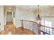 Second story hallway with hardwood floors, wrought iron railing and decorative lighting at 2400 Weber Heights Way, Buford, GA 30519