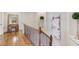 Second floor hallway with hardwood floors, a decorative mirror, and stylish wrought iron banister at 2400 Weber Heights Way, Buford, GA 30519