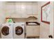 Bright laundry room featuring granite counters, and sink with plenty of cabinet storage at 2400 Weber Heights Way, Buford, GA 30519