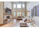 Bright living room with a stone fireplace, high ceilings, and large windows at 2400 Weber Heights Way, Buford, GA 30519