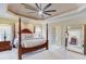 Elegant primary bedroom with a four-poster bed, sitting area, and luxurious finishes at 2400 Weber Heights Way, Buford, GA 30519