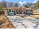 Inviting single-story home with a fresh driveway, manicured lawn, and a delightful front porch seating area at 4493 Old Hiram Lithia Spgs Rd, Powder Springs, GA 30127