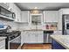 This kitchen is equipped with stainless steel appliances, granite countertops and white cabinets at 4493 Old Hiram Lithia Spgs Rd, Powder Springs, GA 30127