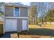 Backyard storage shed or workshop with double doors, a single door, and an open lawn at 4493 Old Hiram Lithia Spgs Rd, Powder Springs, GA 30127