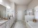 Bright bathroom featuring double sinks, granite countertops, a soaking tub, and a separate glass shower at 134 Jacobs Ln, Loganville, GA 30052