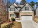 Charming two-story home featuring a stone and gray shingle facade with a well-manicured lawn and two-car garage at 134 Jacobs Ln, Loganville, GA 30052