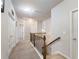 Upstairs hallway with carpet and a beautiful wooden and wrought iron railing at 134 Jacobs Ln, Loganville, GA 30052