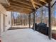 Spacious covered patio featuring wood beams, concrete flooring, and a view of the wooded backyard at 134 Jacobs Ln, Loganville, GA 30052