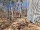 View of the side yard with a pathway alongside the house leading into the wooded area at 134 Jacobs Ln, Loganville, GA 30052