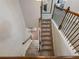 Carpeted staircase featuring wood railing with decorative iron balusters at 134 Jacobs Ln, Loganville, GA 30052