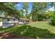 Grassy backyard with a view of the home's exterior, featuring an outdoor patio at 2793 Frontier Trl, Atlanta, GA 30341