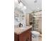 Bright bathroom featuring granite countertop, wood cabinet and glass-enclosed shower with stone accents at 2793 Frontier Trl, Atlanta, GA 30341