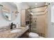 Bright bathroom featuring granite countertop, wood cabinet and glass-enclosed shower with stone accents at 2793 Frontier Trl, Atlanta, GA 30341