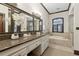 This bathroom offers a vanity with granite counters and custom cabinets and a soaking tub at 320 Morganshire Pl, Atlanta, GA 30350