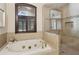 This bathroom features a soaking tub next to a separate shower with tiled walls and a window at 320 Morganshire Pl, Atlanta, GA 30350