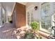 Covered porch with brick floor and white columns, offering a view of the home's exterior and garden at 320 Morganshire Pl, Atlanta, GA 30350