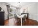 Dining room boasts elegant lighting, wainscoting, and hardwood floors with a view of the front yard at 327 Horseshoe Bnd, Woodstock, GA 30189