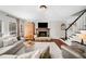 Living room showcases a stone fireplace, hardwood floors, staircase, and large windows for natural light at 327 Horseshoe Bnd, Woodstock, GA 30189