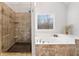 Bright bathroom with a shower and soaking tub and decorative tiles with outside views at 327 Horseshoe Bend Bnd, Woodstock, GA 30189