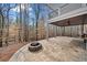 A stone patio featuring a stone fire pit overlooking wooded surroundings at 327 Horseshoe Bend Bnd, Woodstock, GA 30189