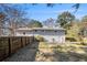 Backyard featuring grassy area, wooden fence, and back of the home with door at 959 Frontier Sw Trl, Marietta, GA 30060