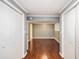 Hallway with hardwood floors and closet space, leading to a gray room with built-in shelves at 959 Frontier Sw Trl, Marietta, GA 30060