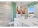 Fresh bathroom with tub and shower combo, white vanity, colorful accents, and a bright window view at 5834 Schelton Se Pl, Mableton, GA 30126