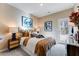 Cozy bedroom with tan walls, decorative pillows, stylish lamps, and framed abstract art above the bed at 5834 Schelton Se Pl, Mableton, GA 30126