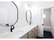 Bright bathroom features double vanity with modern fixtures, oval mirrors, and stylish black and white tiling at 496 Federal Se Ter, Atlanta, GA 30315