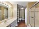 Bathroom featuring vanity, mirror, light fixtures, and tiled shower with glass door at 1101 Juniper St # 61, Atlanta, GA 30309