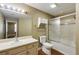 This bathroom features a tub-shower with glass doors, a toilet, and a vanity with bright lighting at 1101 Juniper St # 61, Atlanta, GA 30309