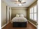 Cozy bedroom with a ceiling fan, hardwood floors, and a closet with white curtains and a window with shutters at 1101 Juniper St # 61, Atlanta, GA 30309