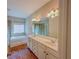 Bathroom with double sink vanity, large mirror, soaking tub, and hardwood floors at 3780 Baxley Pine Trl, Suwanee, GA 30024