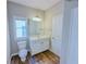 Well lit bathroom with a large mirror, white vanity, and wood-look tile flooring at 3780 Baxley Pine Trl, Suwanee, GA 30024