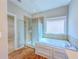 Bathroom featuring a walk-in shower and a soaking tub with a tiled backsplash at 3780 Baxley Pine Trl, Suwanee, GA 30024