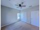Bedroom featuring neutral carpet, ceiling fan, and closet doors, creating a simple and comfortable living space at 3780 Baxley Pine Trl, Suwanee, GA 30024
