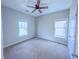 Neutral bedroom featuring a ceiling fan, plush carpet, and two windows for natural light at 3780 Baxley Pine Trl, Suwanee, GA 30024