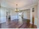 Elegant dining room with hardwood floors, wainscoting, and chandelier lighting at 3780 Baxley Pine Trl, Suwanee, GA 30024