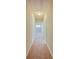 Hallway with neutral colored carpet and walls leading to rooms at the end at 3780 Baxley Pine Trl, Suwanee, GA 30024