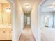 Spacious hallway featuring carpet, neutral paint, and doors to rooms throughout the house at 3780 Baxley Pine Trl, Suwanee, GA 30024