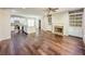 Open-concept living space featuring wood floors, a fireplace, a ceiling fan, and a kitchen at 3780 Baxley Pine Trl, Suwanee, GA 30024