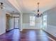 Beautiful living room features hardwood floors, columns, natural light, and a decorative chandelier at 3780 Baxley Pine Trl, Suwanee, GA 30024